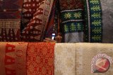 Seorang pengunjung melihat kain Songket Palembang pada pameran kain tradisional "Medan Ethnic Expo" 2016 di Medan, Sumatera Utara, Rabu (21/9). Pameran yang berlangsung hingga 2 Oktober 2016 tersebut menampilkan berbagai produk kain tradisional dan busana dari berbagai daerah di tanah air. ANTARA SUMUT/Septianda Perdana/16