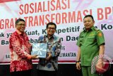 Gubernur Kalbar, Cornelis (kanan) bersama Ketua Dewan Komisioner Otoritas Jasa Keuangan (OJK), Muliaman D Hadad (tengah) dan Direktur Utama Bank Kalbar, Sudirman HMY (kiri) saat pembukaan sosialisasi program transformasi Bank Pembangunan Daerah (BPD) di Kantor Gubernur Kalbar, Senin (26/9). Program transformasi tersebut bertujuan untuk membentuk bank pembangunan daerah yang kuat, kompetitif dan kontributif bagi pembangunan daerah. ANTARA FOTO/Jessica Helena Wuysang/16