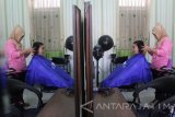 Seorang warga binaan menata rambut konsumennya di Salon An Nisa, Lapas Wanita Kelas II A, Malang, Jawa Timur, Rabu (28/9). Salon kecantikan tersebut sengaja didirikan untuk memberi ketrampilan pada warga binaan sehingga tetap bisa bekerja meski berada di dalam Lempaga Pemasyarakatan (Lapas). Antara Jatim/Ari Bowo Sucipto/zk/16.