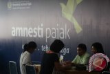 Petugas melayani warga melakukan proses pembayaran pajak saat mengikuti program pengampunan pajak (Amnesti Pajak atau Tax Amnesty) di Kantor Pelayanan Pajak Sumut Wilayah I Medan, Sumatera Utara, Kamis (29/9). Hingga Kamis 29 September 2016, Kantor Wilayah Direktorat Jenderal Pajak (DJP) Sumut I jumlah penerimaan tebusan para wajib pajak yang berhasil dihimpun sebesar 3,5 triliun atau hampir mendekati target sebesar Rp 4,4 triliun. ANTARA SUMUT/Septianda Perdana/16
