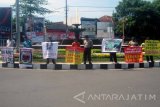 Sejumlah aktivis LSM di Kabupaten Jember, Jawa Timur melakukan aksi damai peringatan G 30 S PKI dengan membawa sejumlah poster di bundaran DPRD setempat, Jumat (30/9). Para aktivis LSM menyerukan masyarakat untuk memerangi dan menolak komunisme  di Jember. Antara Jatim/ Zumrotun Solichah/zk/16
