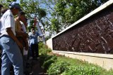 Sejumlah pelajar mendengarkan pemandu sejarah Gayeng Gunarto yang menjelaskan tentang sejarah gerakan dan tumbangnya Partai Komunis Indonesia (PKI) seusai mengikuti upacara peringatan Hari Kesaktian Pancasila di areal Monumen Korban Keganasan PKI di Kresek, Kabupaten Madiun, Jawa Timur, Sabtu (1/10). Pemkab Madiun menggelar upacara Hari Kesaktian Pancasila di lokasi tersebut yang diikuti pejabat, prajurit TNI, Polri, pelajar dan tokoh masyarakat untuk mengenang sekaligus sebagai refleksi peristiwa pembantaian 1948. Antara Jatim/Foto/Siswowidodo/zk/16