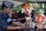 Peserta mengukir dan merangkai buah saat lomba mengukir buah di Kota Denpasar, Bali, Sabtu (1/10). Lomba mengukir buah yang diikuti puluhan peserta tersebut digelar untuk meningkatkan keterampilan dan kualitas pengolahan buah terutama buah lokal agar lebih diminati konsumen. ANTARA FOTO/Fikri Yusuf/wdy/16