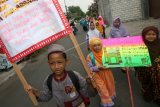 Sejumlah pelajar sekolah dasar membawa poster saat mengikuti pawai Tahun Baru Hijriah 1438 di Kota Kediri, Jawa Timur, Jumat (30/9). Kegiatan tersebut bertujuan untuk menyambut sekaligus memeriahkan Tahun Baru Hijriah. ANTARA FOTO/Prasetia Fauzani/kye/16