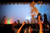 Sejumlah dalang memainkan wayang kulit di depan dan belakang layar dengan lakon 'Nrimo Wahyu Kamukten Kamulyan Kaluhuran' guna memeriahkan tahun baru penanggalan Jawa di Kota Kediri, Jawa Timur, Minggu (2/10) malam. Wayang kreasi baru yang dimainkan oleh sepuluh dalang muda dari Surakarta tersebut bertujuan menarik perhatian generasi muda agar mencintai sekaligus melestarikan wayang kulit. Antara Jatim/Prasetia Fauzani/zk/16