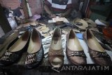 Pekerja menyelesaikan pembuatan sepatu di industri sepatu rumahan di Surabaya, Jawa Timur, Selasa (4/10). Sepatu berbahan baku kulit imitasi atau sintetis tersebut dipasarkan ke sejumlah daerah di Jawa Timur seperti Sidoarjo, Mojokerto, Malang, bahkan hingga ke Bali dan NTT dengan harga mulai Rp450.000 sampai Rp750.000 perkodi (20 buah) tergantung model dan tingkat kerumitan pembuatannya. Antara Jatim/Moch Asim/zk/16