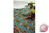 Seorang staf memperlihatkan kain batik khas Kayong Utara di galeri Dewan Kerajinan Nasional Daerah (Dekranasda) Kabupaten Kayong Utara, Kalbar, Senin (3/10). Kain batik khas Kayong Utara yang bercorak ornamen ikan dan durian tersebut, dijual seharga Rp75 ribu per meter. ANTARA FOTO/Jessica Helena Wuysang/16