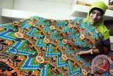 Seorang staf memperlihatkan kain batik khas Kayong Utara di galeri Dewan Kerajinan Nasional Daerah (Dekranasda) Kabupaten Kayong Utara, Kalbar, Senin (3/10). Kain batik khas Kayong Utara yang bercorak ornamen ikan dan durian tersebut, dijual seharga Rp75 ribu per meter. ANTARA FOTO/Jessica Helena Wuysang/16