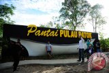 Sejumlah warga berfoto di depan gapura Pantai Pulau Datok di Sukadana, Kabupaten Kayong Utara, Kalbar, Minggu (2/10). Pantai Pulau Datok yang merupakan perpaduan antara pantai, bukit dan teluk tersebut, menjadi salah satu objek wisata unggulan Sukadana, Kabupaten Kayong Utara. ANTARA FOTO/Jessica Helena Wuysang/16