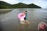 Seorang anak membawa pelampung saat bermain di Pantai Pulau Datok, Sukadana, Kabupaten Kayong Utara, Kalbar, Minggu (2/10). Pantai Pulau Datok yang merupakan perpaduan antara pantai, bukit dan teluk tersebut, menjadi salah satu objek wisata unggulan Sukadana, Kabupaten Kayong Utara. ANTARA FOTO/Jessica Helena Wuysang/16