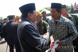 Gubernur Jawa Timur, Soekarwo (kiri) secara simboilis menyerahkan kunci merupakan program bedah rumah BUMN untuk Negeri pada anggota keluarga veteran usai upacara peringatan HUT ke-71 TNI di Makodam V Brawijaya Surabaya, Jawa Timur, Rabu (5/10). HUT ke-71 TNI mengambil tema Bersama Rakyat TNI kuat, Hebat, Profesional, Siap Mewujudkan Indoensia Yang Berdaulat, Mandiri dan Berkepribadian. Antara Jatim/M Risyal Hidayat/zk/16