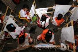 Sejumlah anak mengikuti lomba membatik di Taman Blambangan, Banyuwangi, Jawa Timur, Kamis (6/9). Lomba membatik yang dikuti ratusan anak-anak tingkat Sekolah Dasar tersebut, sebagai sarana edukasi yang diselenggarakan pemerintah daerah setempat untuk melestarikan Batik Banyuwangi. Antara Jatim/ Budi Candra Setya/zk/16.