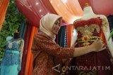 Penjual jasa pernikahan menata baju pengantin bertema kebaya modern di salah satu stand dalam Pameran Kebutuhan Pernikahan di Malang, Jawa Timur, Kamis (6/10). Pameran yang diadakan selama tiga hari tersebut digelar untuk membantu masyarakat dalam memenuhi kebutuhan pernikahan yang dalam sebulan terakhir meningkat. Antara Jatim/Ari Bowo Sucipto/zk/16.
