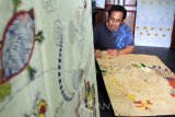 Seniman batik melakukan pewarnaan di atas pola batik lukis dengan media tusuk gigi di Balai Budaya Gayatri, Tulungagung, Jawa Timur, Kamis (6/10). Batik lukis dengan sarana gambar alat tusuk gigi pengganti canting itu menjadi inovasi baru di khasanah perbatikan nasional dengan durasi pengerjaan antara 1-2 bulan dan harga jual berkisar Rp1,5 juta hingga Rp5 juta per lembar. Antara Jatim/Destyan Sujarwoko/zk/16