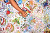 Seniman batik melakukan pewarnaan di atas pola batik lukis dengan media tusuk gigi di Balai Budaya Gayatri, Tulungagung, Jawa Timur, Kamis (6/10). Batik lukis dengan sarana gambar alat tusuk gigi pengganti canting itu menjadi inovasi baru di khasanah perbatikan nasional dengan durasi pengerjaan antara 1-2 bulan dan harga jual berkisar Rp1,5 juta hingga Rp5 juta per lembar. Antara Jatim/Destyan Sujarwoko/zk/16