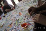 Seniman batik melakukan pewarnaan di atas pola batik lukis dengan media tusuk gigi di Balai Budaya Gayatri, Tulungagung, Jawa Timur, Kamis (6/10). Batik lukis dengan sarana gambar alat tusuk gigi pengganti canting itu menjadi inovasi baru di khasanah perbatikan nasional dengan durasi pengerjaan antara 1-2 bulan dan harga jual berkisar Rp1,5 juta hingga Rp5 juta per lembar. Antara jatim/Destyan Sujarwoko/zk/16