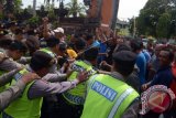 Sejumlah pengunjuk rasa saling dorong dengan polisi saat simulasi penanganan huru-hara di Pengadilan Negeri Denpasar, Jumat (7/10). Simulasi tersebut diikuti oleh polisi, kejaksaan dan pemadam kebaran untuk meningkatkan kemampuan petugas dalam menangani huru-hara yang sering terjadi di pengadilan. ANTARA FOTO/Wira Suryantala/wdy/16.