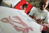Seniman melukis di atas media kaos polos menggunakan tinta warna berbahan alami yang digoreskan dengan alat tusuk gigi di Tulungagung, Jawa Timur, Kamis (6/10). Kaos lukis itu dijual dengan harga Rp100 ribu - Rp1 juta per buah dan dipasarkan secara online ke sejumlah kota besar di Indonesia. ANTARA FOTO/Destyan Sujarwoko/wdy/16