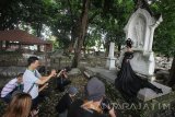 Sejumlah fotografer memotret model di kawasan Makam Belanda Peneleh, Surabaya, Jawa Timur, Minggu (9/10). Kegiatan pemotretan yang mengangkat tema 'Dark Beauty' tersebut merupakan salah satu upaya untuk melestarikan Makam Belanda Peneleh yang menjadi salah satu cagar budaya melalui media fotografi. Antara Jatim/Moch Asim/zk/16