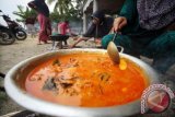 Masyarakat petani memasak masakan Ayam saat berlangsung kenduri 'blang' (kenduri turun kesawah) di Desa Meunasah Kumbang, Kuta Makmur, Aceh Utara, Provinsi Aceh, Minggu (9/10). Kenduri blang memasak ayam dan sajian bu kulah (nasi bungkus daun pisang) secara massal di kawasan persawahan itu merupakan tradisi petani turun ke sawah untuk menanam padi yang sudah dilakukan secara turun temurun agar padi terhindar dari serangan hama dan memperoleh hasil panen yang melimpah. ANTARA FOTO/Rahmad/foc/16.
