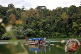 Pengunjung berada di atas rakit wisata Danau Lingkat di kawasan Desa Adat Lekuk 50 Tumbi Lempur, Gunung Raya, Kerinci, Jambi, Minggu (2/10). Desa Adat Lekuk 50 Tumbi Lempur yang di dalam kawasannya terdapat lima danau merupakan satu kawasan wisata terpadu yang terdiri dari satu kelurahan dan empat desa yang saat ini tengah dikembangkan oleh pemerintah daerah setempat sebagai salah satu kawasan wisata alternatif yang pengelolaan hutannya telah dikelola secara adat. ANTARA FOTO/Wahdi Septiawan/pd/16.