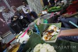 Pedagang Bubur Madura melayani pembeli saat berjualan di Pasar Atum, Surabaya, Jawa Timur, Selasa (11/10). Bubur Madura yang dijual dengan harga Rp10.000 untuk satu porsi tersebut merupakan salah satu makanan khas Jawa Timur yang disajikan dengan menggabungkan bubur sumsum, bubur ketan hitam, bubur candil, bubur mutiara dan ditambahkan santan serta gula merah. Antara jatim/Moch Asim/zk/16