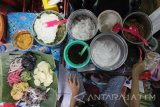 Pedagang Bubur Madura melayani pembeli saat berjualan di Pasar Atum, Surabaya, Jawa Timur, Selasa (11/10). Bubur Madura yang dijual dengan harga Rp10.000 untuk satu porsi tersebut merupakan salah satu makanan khas Jawa Timur yang disajikan dengan menggabungkan bubur sumsum, bubur ketan hitam, bubur candil, bubur mutiara dan ditambahkan santan serta gula merah. Antara jatim/Moch Asim/zk/16