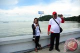 Dua wisatawan lokal melakukan swafoto di Pantai Pulau Datok di Kecamatan Sukadana, Kabupaten Kayong Utara, Kalbar, Kamis (13/10). Pantai Pulau Datok yang merupakan perpaduan antara pantai, bukit dan teluk tersebut, dipersiapkan pemerintah daerah Kabupaten Kayong Utara untuk menjadi destinasi wisata unggulan. ANTARA FOTO/Jessica Helena Wuysang/16