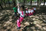 Pelajar Taman Kanak-Kanak (TK) bermain ayunan tali dengan didampingi petugas di Surabaya, Jawa Timur, Rabu (12/10). Kegiatan yang dilakukan puluhan pelajar TK At-Taufiq tersebut guna melatih otot, keberanian dan pengenalan alam kepada anak. Antara Jatim/Didik Suhartono/zk/16