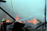 Pemadam menyemprotkan air untuk memadamkan api yang membakar toko dan gudang kayu kiloan di Tulungagung, Jawa Timur, Jumat (14/10). Kebakaran diduga dipicu konsleting listrik dan menyebabkan kerugian ratusan juta rupiah. Antara Jatim/Destyan Sujarwoko/zk/16
