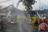 Petugas berusaha memadamkan api yang membakar Kantor Dinas Pekerjaan Umum (PU) Kota Denpasar, Bali, Jumat (14/10). Kebakaran yang membakar sejumlah ruangan penyimpanan arsip dan alat milik Dinas PU Kota Denpasar tersebut diperkirakan terjadi akibat hubungan pendek arus listrik. ANTARA FOTO/Fikri Yusuf/wdy/16