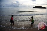 Dua anak bermain di Pantai Pulau Datok di Kecamatan Sukadana, Kabupaten Kayong Utara, Kalbar, Kamis (13/10). Pantai Pulau Datok yang merupakan perpaduan antara laut, bukit dan teluk tersebut, memiliki keindahan alam yang mempesona hingga menjadi salah satu destinasi wisata unggulan Kabupaten Kayong Utara. ANTARA FOTO/Jessica Helena Wuysang/16
