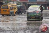 Pengendara mobil berusaha menghindari jalan rusak yang terendam air di kawasan Jalan Titi Papan Medan, Sumatera Utara, Jumat (14/10). Kerusakan jalan yang tidak kunjung diperbaiki itu kerap menimbulkan kecelakaan dan mengganggu aktivitas masyarakat. ANTARA SUMUT/Septianda Perdana