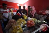 Menteri Sosial Khofifah Indar Parawansa (kanan) membeli produk makanan milik warga saat meluncurkan program Elektronik Warung Gotong Royong Kelompok Usaha Bersama Program Keluarga Harapan (E-Warong KUBE PKH) di Medan, Sumatera Utara, Jumat (14/10). E-Warong selain dapat digunakan untuk mengambil dana Program Keluarga Harapan (PKH) juga sebagai sarana jual beli non tunai bagi peserta PKH yang menjadi solusi atas pencegahan berbagai praktik penyelewengan dalam penyaluran bantuan sosial (bansos) non-tunai kepada masyarakat miskin. ANTARA SUMUT/Septianda Perdana