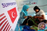 Pengungsi etnis Rohingya (kanan) menyelesaikan anyaman tas Talikur saat pelatihan di Shelter Blang Adoe, Kuta Makmur, Aceh Utara, Provinsi Aceh, Kamis (13/10). tas hasil pelatihan kerajinan tangan Tas Talikur Rohingya itu kemudian dijual Rp70.000 hingga Rp300.000 tergantung ukuran dan modelnya, sebagai pemberdayaan ekonomi dan kemampuan pengungsi. ANTARA FOTO/Rahmad/aww/16.