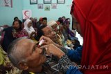 Petugas meneteskan cairan pada mata pasien sebelum menjalani operasi katarak saat digelar bakti sosial operasi katarak di sebuah klinik di Kota Madiun, Jawa Timur, Sabtu (15/10). Bakti sosial operasi katarak yang digelar Persatuan Dokter Spesialis Mata Indonesia (Perdami) Cabang Jawa Timur berkerja sama dengan sebuah perusahaan jamu tersebut melakukan operasi terhadap 52 orang pasien yang memenuhi syarat untuk dilakukan operasi dari 103 orang yang mendaftar. Antara Jatim/Foto//Siswowidodo/zk/16