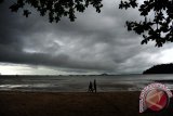 Tiga warga berjalan di tepian Pantai Pulau Datok, Kecamatan Sukadana, Kabupaten Kayong Utara, Kalbar, Sabtu (15/10). Badan Meteorologi Klimatologi dan Geofisika (BMKG) menyatakan bahwa dari Sabtu (15/10) hingga Senin (17/10) diperkirakan akan terjadi hujan lebat disertai petir dan angin kencang atau puting beliung di wilayah Kalimantan Barat. ANTARA FOTO/Jessica Helena Wuysang/16