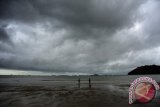 Dua warga berdiri di tepian Pantai Pulau Datok, Kecamatan Sukadana, Kabupaten Kayong Utara, Kalbar, Sabtu (15/10). Badan Meteorologi Klimatologi dan Geofisika (BMKG) menyatakan bahwa dari Sabtu (15/10) hingga Senin (17/10) diperkirakan akan terjadi hujan lebat disertai petir dan angin kencang atau puting beliung di wilayah Kalimantan Barat. ANTARA FOTO/Jessica Helena Wuysang/16