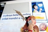 Seorang perempuan berkostum etnik Dayak berkomunikasi menggunakan telpon genggam di depan mobil Anjungan Tunai Mandiri di Pameran Sail Karimata 2016 di Pantai Pulau Datok, Kecamatan Sukadana, Kabupaten Kayong Utara, Kalbar, Sabtu (15/10). Bank Mandiri mengembangkan produk Mandiri e-cash untuk mendukung program Layanan Keuangan Digital (LKD), guna menciptakan sistem keuangan perbankan yang mudah, cepat dan dapat dijangkau masyarakat. ANTARA FOTO/Jessica Helena Wuysang/16