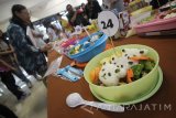 Seorang juri melakukan penilaian kreasi bekal makanan saat lomba menyusun bekal makanan untuk anak SD di Surabaya, Jawa Timur, Senin (17/10). Kegiatan yang diikuti oleh 50 peserta tersebut bertujuan untuk mengajarkan bagaimana menyediakan bekal makanan yang sesuai dengan nutrisi bagi anak SD sekaligus dalam rangka merayakan Lustrum ke-6 atau 30 Tahun berdirinya Fakultas Pertanian jurusan Pangan Universitas Katolik Widya Mandala (UKWM) Surabaya. Antara jatim/Moch Asim/zk/16