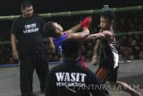 Pesilat bertarung saat tradisi Pencak Dor memperingati Hari Santri Nasional di Kelurahan Banaran, Kota Kediri, Jawa Timur, Sabtu (15/10) malam. Tarung bebas yang berasal dari tradisi pondok pesantren Lirboyo tersebut guna mempererat persahabatan antar perguruan silat. Antara Jatim/Prasetia Fauzani/zk/16