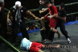 Wasit melerai dua orang pesilat saat tradisi Pencak Dor memperingati Hari Santri Nasional di Kelurahan Banaran, Kota Kediri, Jawa Timur, Sabtu (15/10) malam. Tarung bebas yang berasal dari tradisi pondok pesantren Lirboyo tersebut guna mempererat persahabatan antar perguruan silat. Antara Jatim/Prasetia Fauzani/zk/16