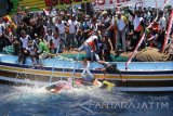 Ratusan kapal nelayan mengikuti larung sesaji saat tradisi petik laut di Muncar, Banyuwangi, Jawa Timur, Minggu (16/10). Tradisi yang digelar masyarakat pesisir muncar tersebut, sebagai ungkapan rasa syukur para nelayan atas hasil tangkapan ikan yang melimpah, sekaligus ritual tolak bala memohon keselamatan agar terhindar dari bahaya saat berlayar mengarungi lautan. Antara Jatim/Budi Candra Setya/zk/16.