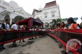 Sejumlah pelajar membentangkan kain ulos sepanjang 500 meter pada Perayaan Hari Ulos di Medan, Sumatera Utara, Senin (17/10). Perayaan hari ulos yang telah ditetapkan oleh pemerintah sejak 17 Oktober 2014 sebagai warisan budaya tak benda nasional itu diselenggarakan sebagai kepedulian masyarakat Batak dalam melestarikan budaya lokal. ANTARA SUMUT/Septianda Perdana/16