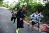 Petinju Daud Yordan (dua kiri) menjalani latihan lari bersama empat petinju Sasana 24/7 Daud Yordan Boxing Club di Kecamatan Sukadana, Kabupaten Kayong Utara, Kalbar, Senin (17/10). Juara tinju kelas ringan (62,1 kilogram) WBO Asia Pasifik, Daud Yordan membina empat petinju profesional yaitu Antony Holt, Hisar Pacman Mawan, Sunardi Gamboa dan Hiyar Ismansyah yang diharapkan bisa menjadi bibit petinju di masa mendatang. ANTARA FOTO/Jessica Helena Wuysang/16