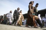 Sejumlah pasangan melakukan pawai sebelum dilaksanakannya prosesi nikah massal yang diselenggarakan oleh sejumlah pesantren Nahdlatul Ulama yang tergabung dalam Rabitha Ma'ahid Islamiyah (RMI) di Kota Kediri, Jawa Timur, Sabtu (22/10). Nikah massal yang diikuti oleh 50 pasangan penganting berbagai usia dari keluarga kurang mampu tersebut guna memeriahkan hari santri nasional sekaligus berupaya mengedukasi masyarakat tentang pentingnya menikah secara resmi yang tercatat oleh negara. Antara Jatim/Prasetia Fauzani/zk/16