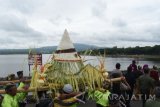 Sejumlah orang mengirab sesaji sebelum dilarung di Waduk Widas, Kabupaten Madiun, Jawa Timur, Minggu (23/10). Para petani ikan bersama warga sekitar Waduk Widas menggelar tradisi larung sesaji, selain sebagai ungkapan rasa syukur juga promosi wisata alam waduk. Antara Jatim/Foto/Siswowidodo/zk/16