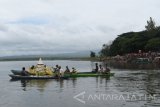 Sejumlah orang melarung sesaji di Waduk Widas, Kabupaten Madiun, Jawa Timur, Minggu (23/10). Para petani ikan bersama warga sekitar Waduk Widas menggelar tradisi larung sesaji, selain sebagai ungkapan rasa syukur juga promosi wisata alam waduk. Antara Jatim/Foto/Siswowidodo/zk/16