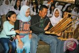 Menpora Imam Nahrawi (tengah) berbincang sambil belajar alat musik tradisional Angklung bersama siswi SMAN 14 Bandung saat Roadshow Bank Musik dan Gelar Musik Angklung di Saung Angklung Udjo (SAU), Bandung, Jawa Barat, Minggu (23/10). Bank Musik sebagai wadah karya seni dan ruang publik yang digagas Menpora ini untuk meningkatkan potensi sektor kreatif berbasis tradisi dan budaya terhadap lagu daerah serta alat musik tradisional kepada pemuda menuju Gerakan Nasional Pemuda Kreatif. ANTARA FOTO/Fahrul Jayadiputra/wdy/16