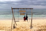 Wisatawan melintasi pantai  Pulau Tabuhan di  Banyuwangi, Jawa Timur, Sabtu (22/10). Pualau seluas lima hektar yang tidak berpenghuni tersebut, menjadi salah satu tempat wisata yang menawarkan keindahan pantai yang masih alami. Antara Jatim/Budi Candra Setya/zk/16.